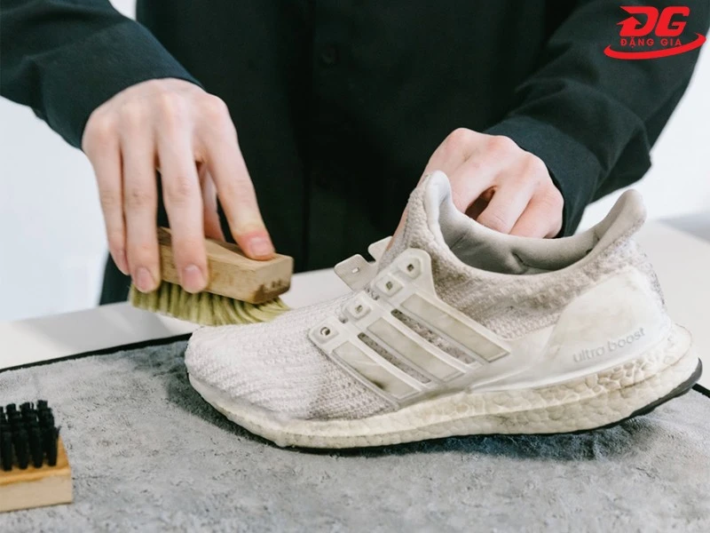 Dùng bàn chải làm sạch sơ bộ bụi bẩn dính trên giày