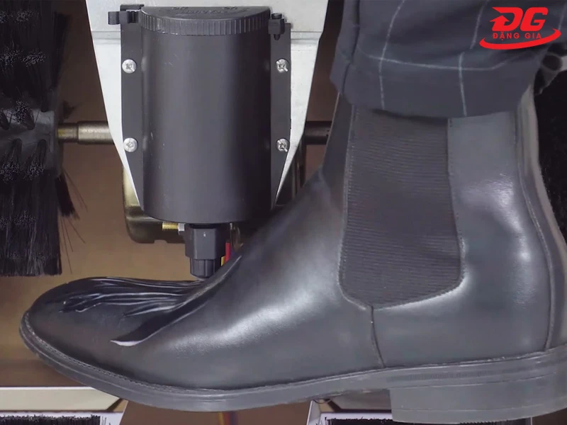 Chạm nhẹ giày vào van bi bên dưới hộp đựng xi để lấy xi