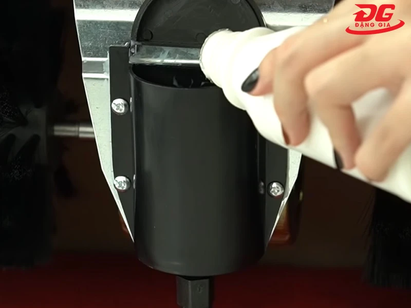 Mở nắp hộp đựng xi ở giữa hai chổi và đổ xi vào.