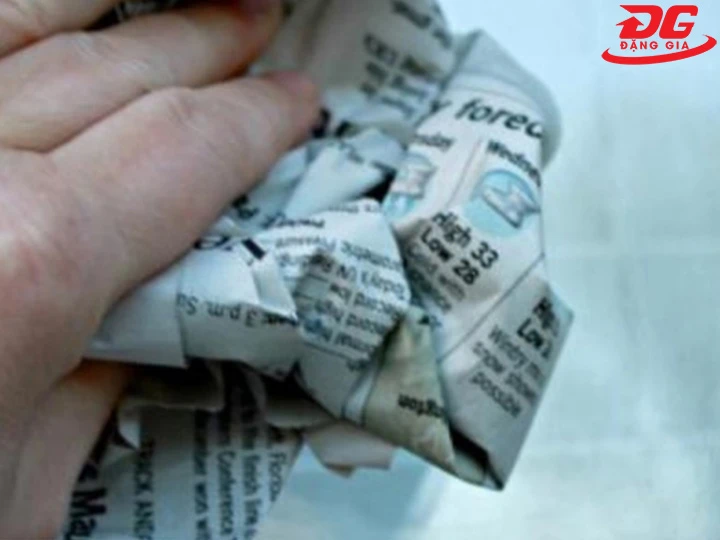 Dùng giấy báo cũ làm sạch kính nhà tắm